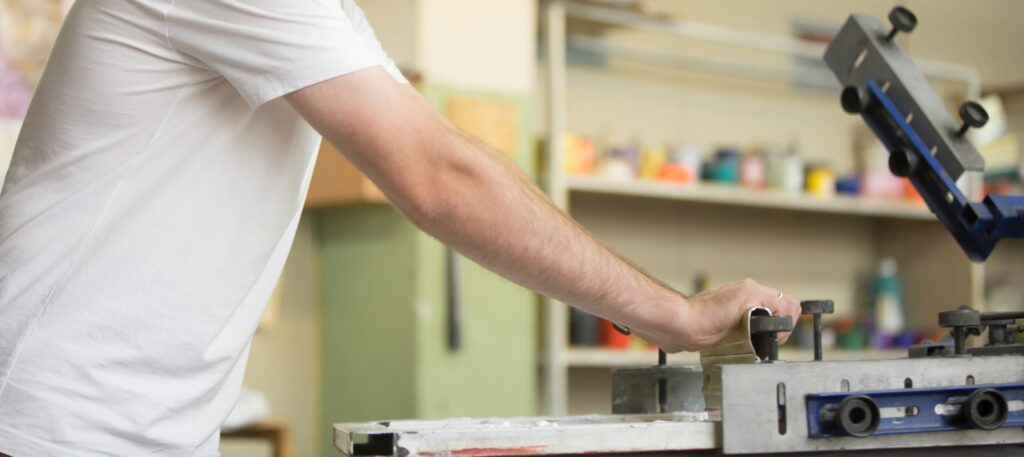 Một chàng trai trẻ đang in áo thun